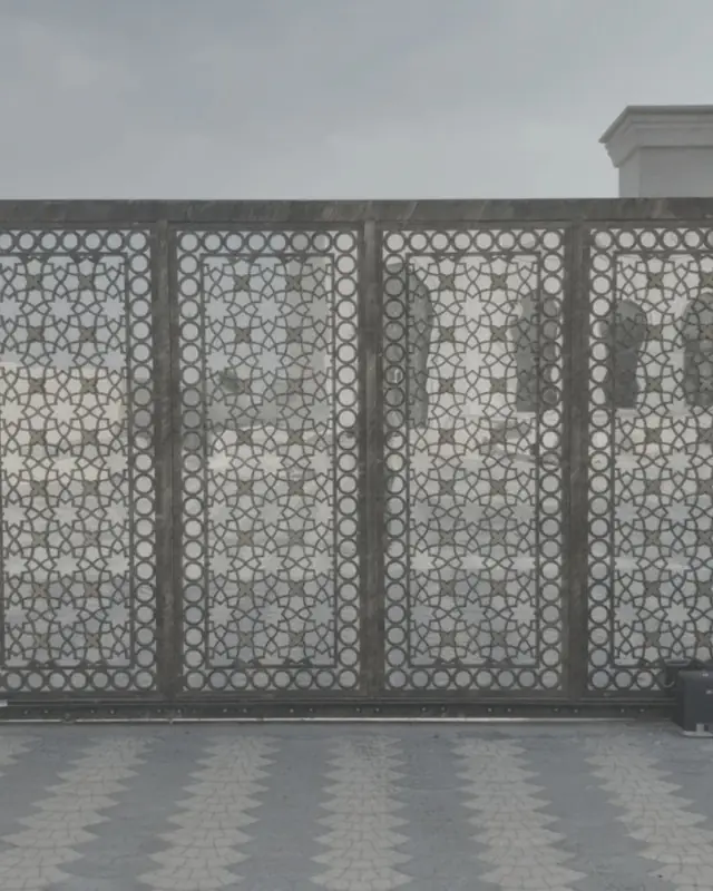 Sliding gate with four laser-cut geometric panels in a bronze finish, between two rendered pillars